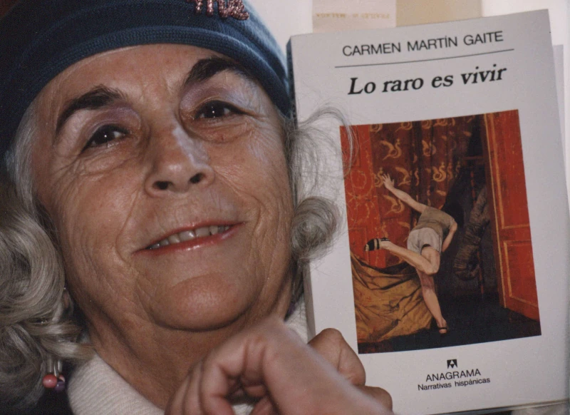 Carmen Martín Gaite posando con el libro Lo raro es vivir